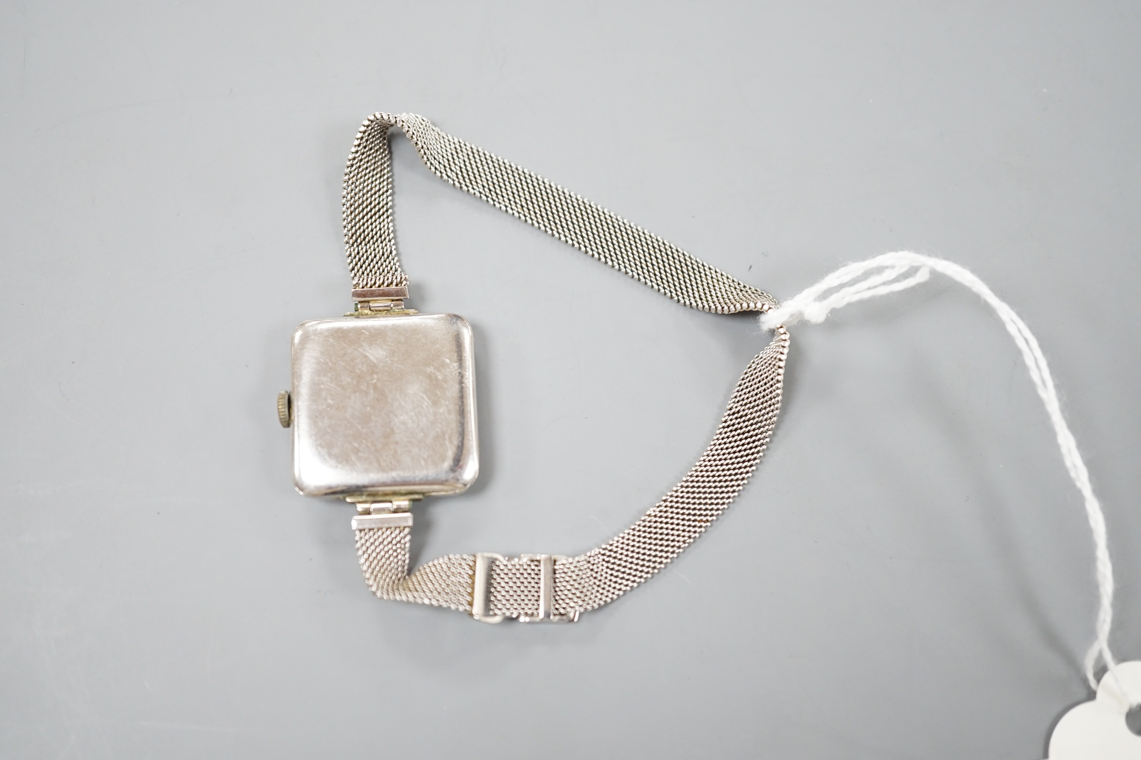 A lady's early 20th century white metal (stamped Plat) and diamond chip set manual wind cocktail watch, on a later 9ct white gold mesh link bracelet, gross 26.3 grams, (stone missing).